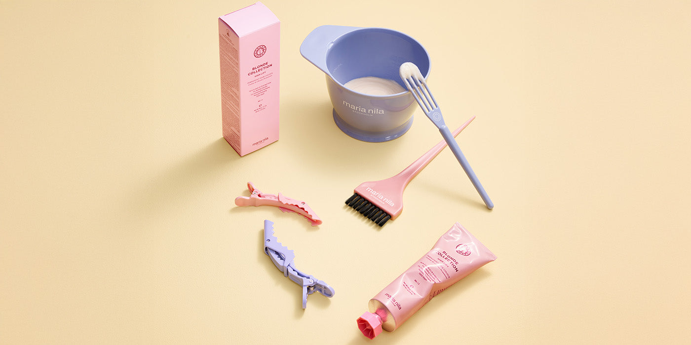 Still life of tubes of hair color, bowl with formula and brushes on yellow background